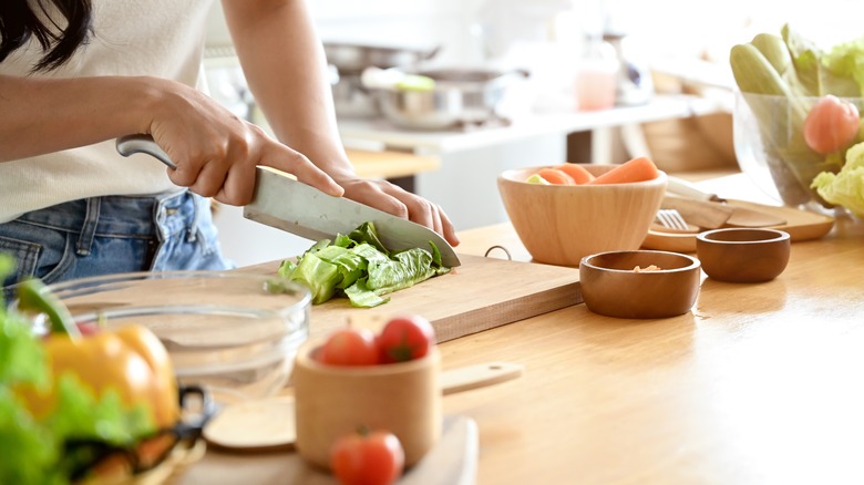 A woman cutting ingredients in the kitchen