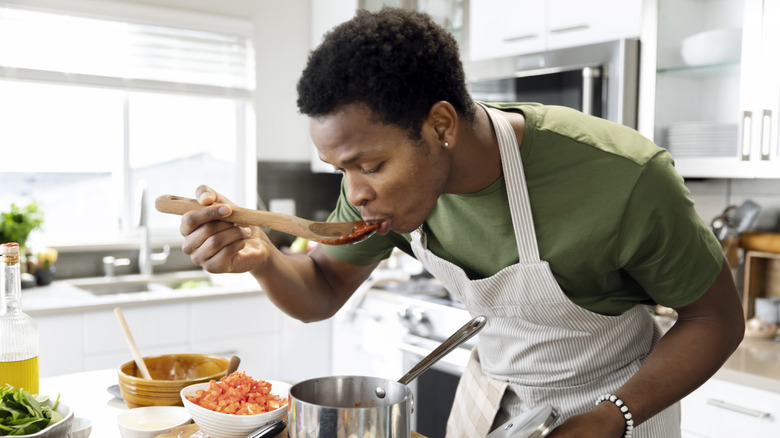 A man tasting sauce