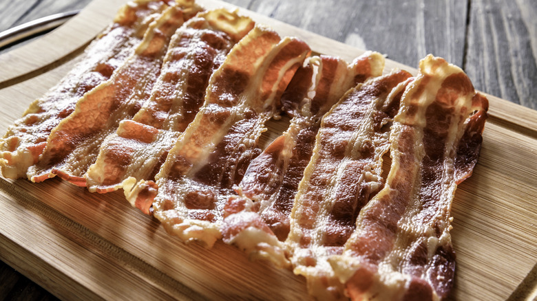 Cooked bacon on wooden cutting board