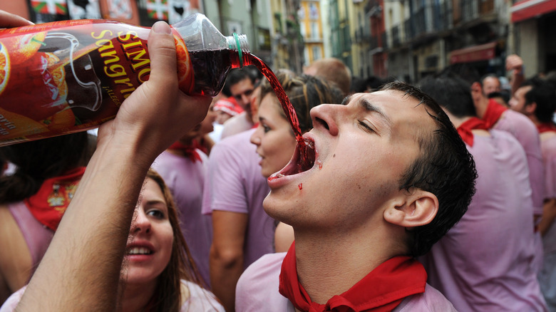 Reveler drinks sangria in spain at San Fermin Festival