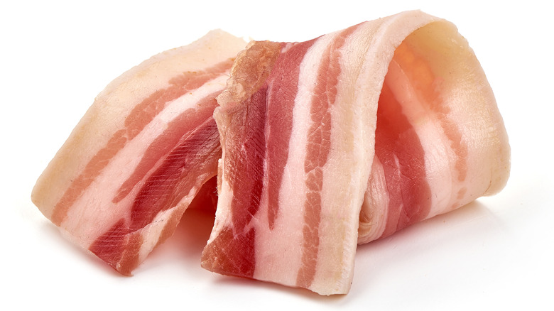 Raw bacon on white background