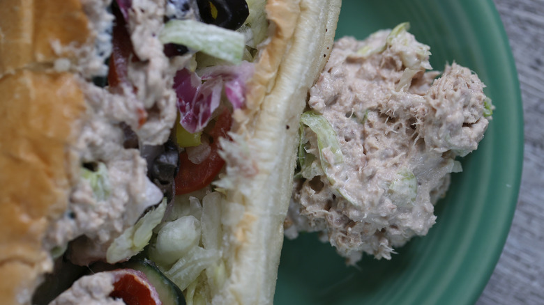 A scoop of Subway's tuna on a plate, next to a tuna sandwich