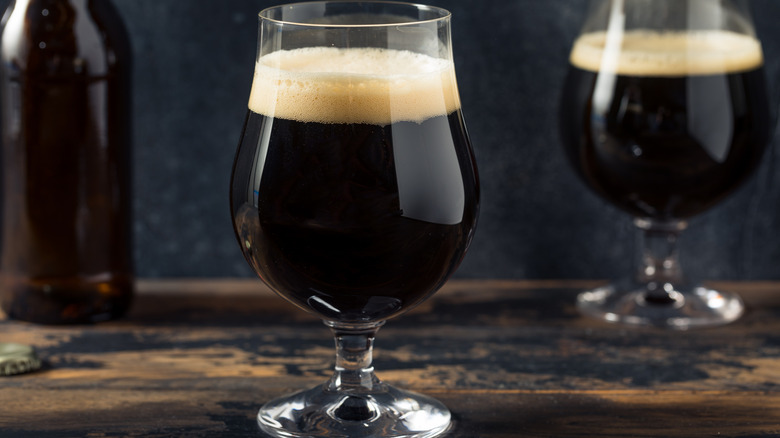 Glasses of porter beer in dark background