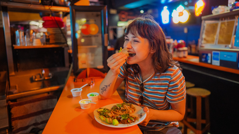 Girl eating taco in bar