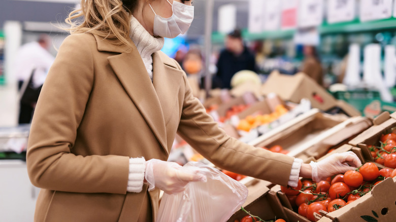 Woman buys tomatoes at store