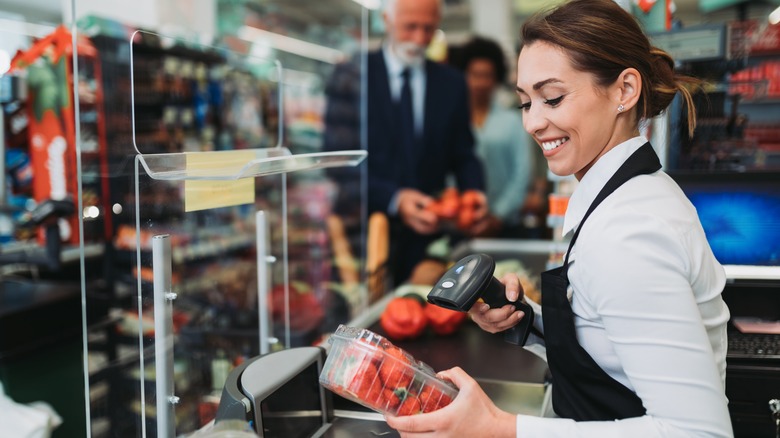 Grocery store cashier scanning tomatoes