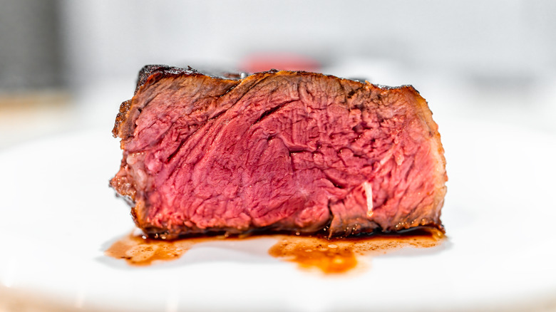 Blue steak on white plate, sliced to expose the center