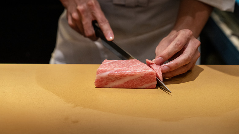 chef slicing well-marbled tuna