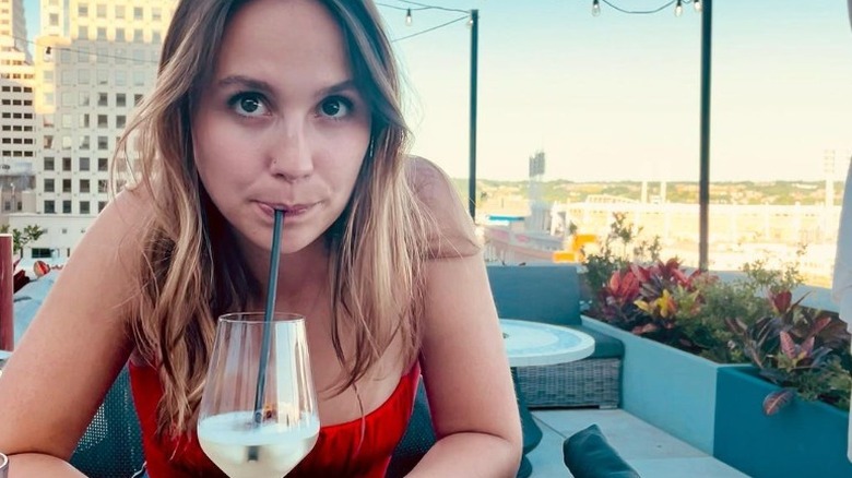 Woman drinking through straw on rooftop patio