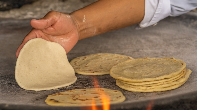 Someone cooking handmade tortillas