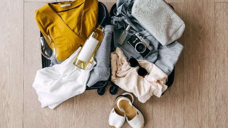 Open suitcase with wine bottle