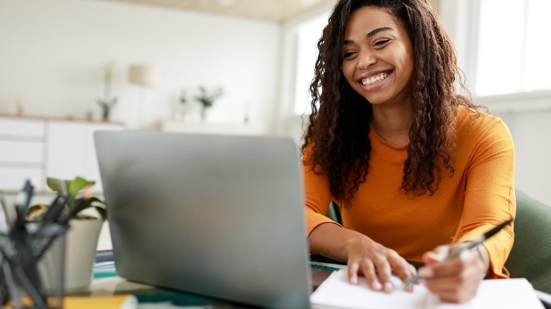 Smiling woman looking at computer screen 