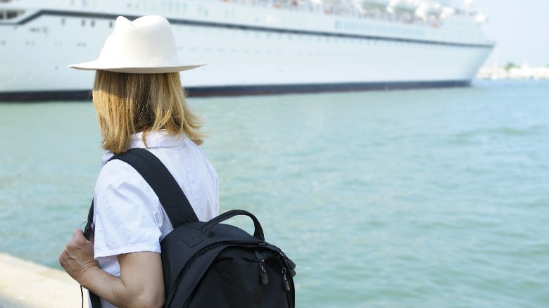 Woman with backpack looking at ship