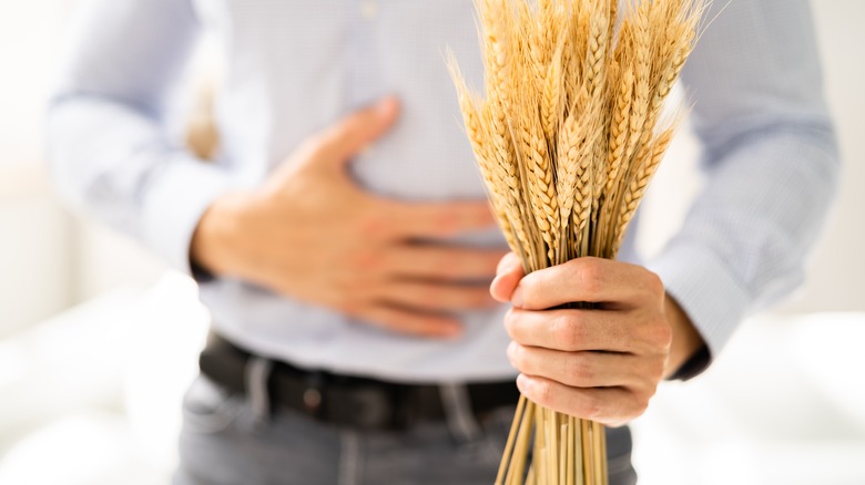 Man holding wheat and his stomach