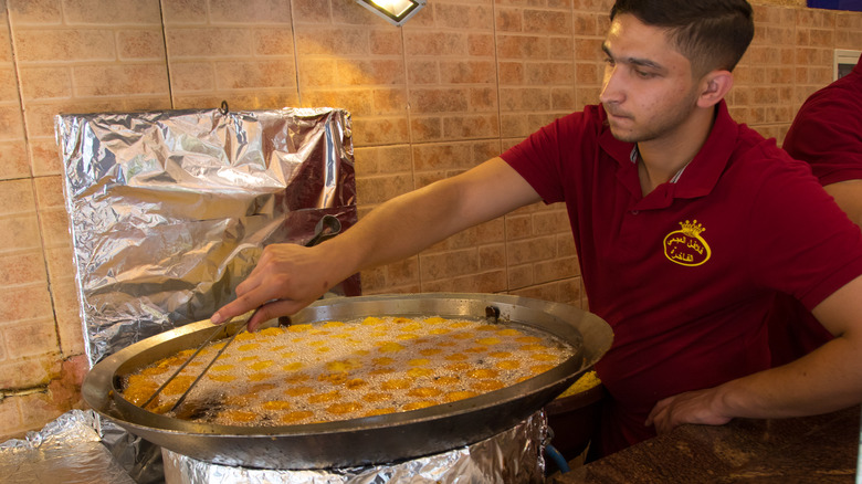 Man deep frying falafel