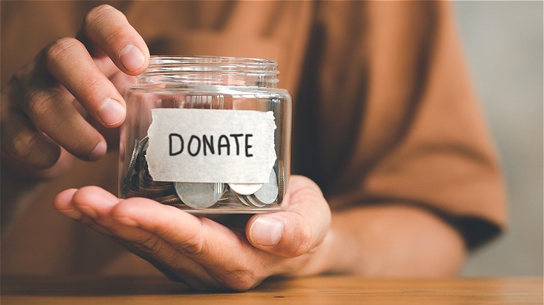 hands holding charity fund jar 