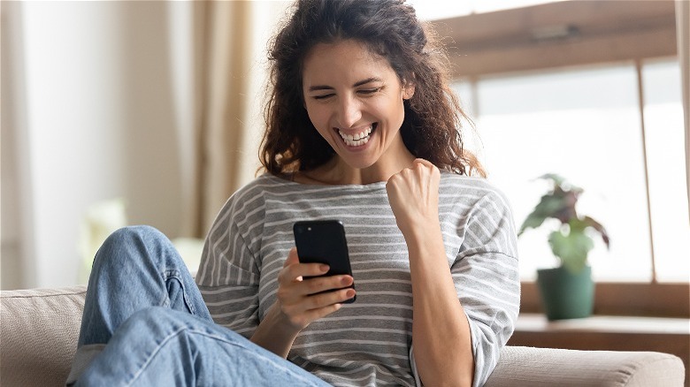 excited woman looking at phone