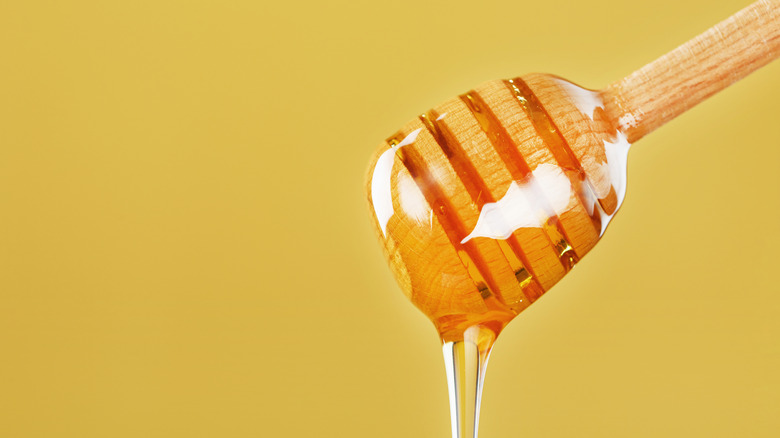 Honey dripping from honey dipper