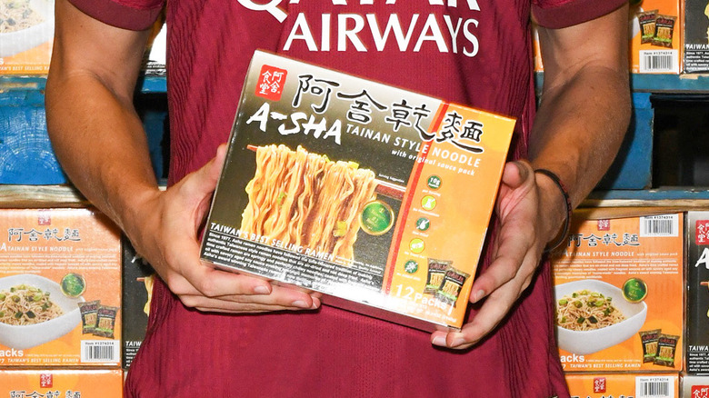 Person holding box of A-sha instant ramen