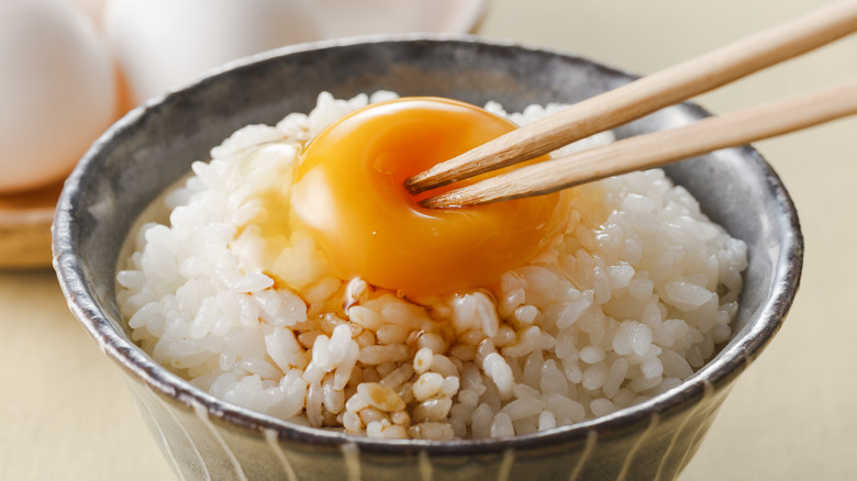 raw egg on rice bowl 