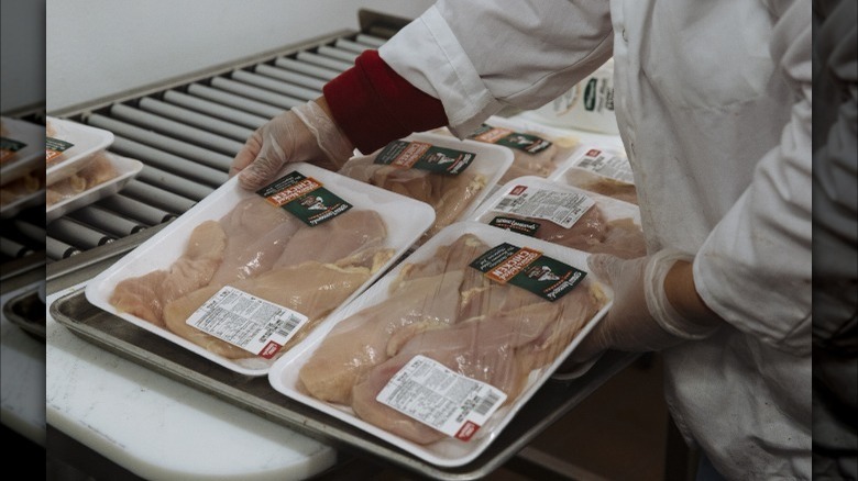 Butcher prepares chicken breast packages