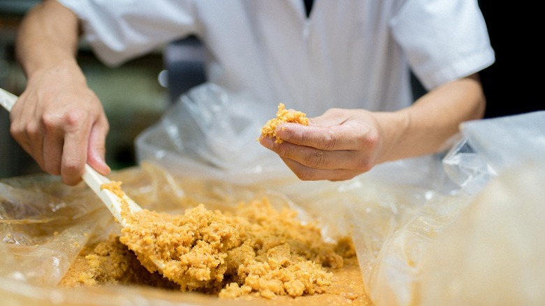 hands scooping miso paste