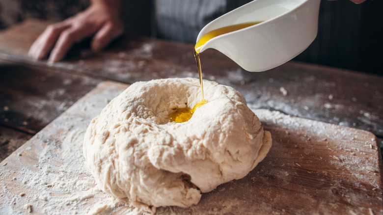 olive oil pouring onto dough