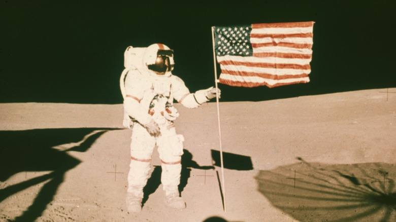 Astronaut on moon holding flag