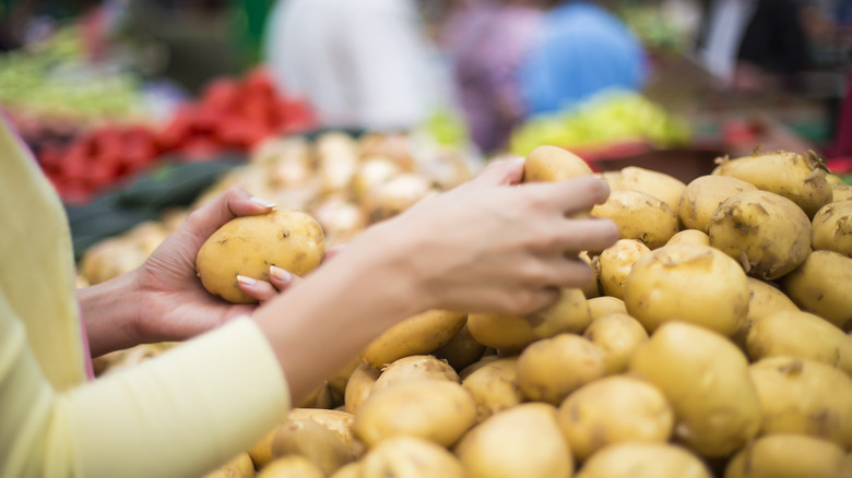 selecting potatoes in supermarket