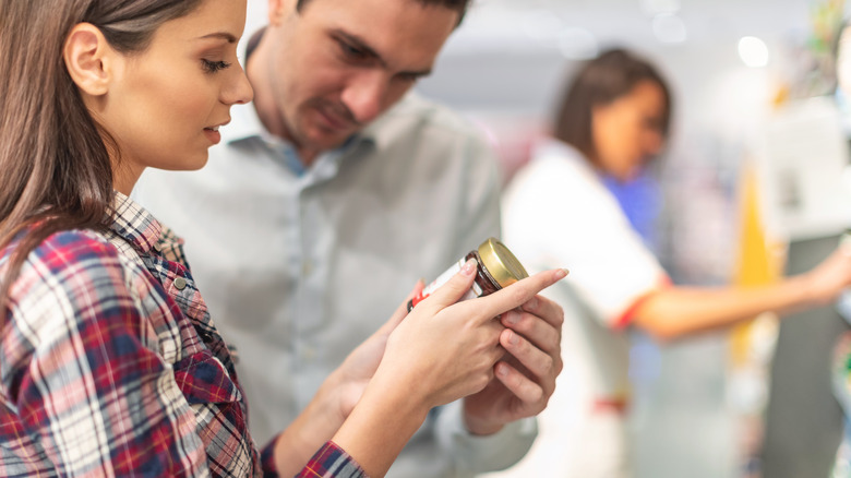 couple checking ingredients of jar