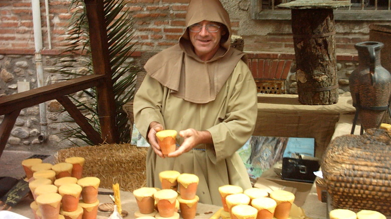 A man selling jars of honey at a medieval market