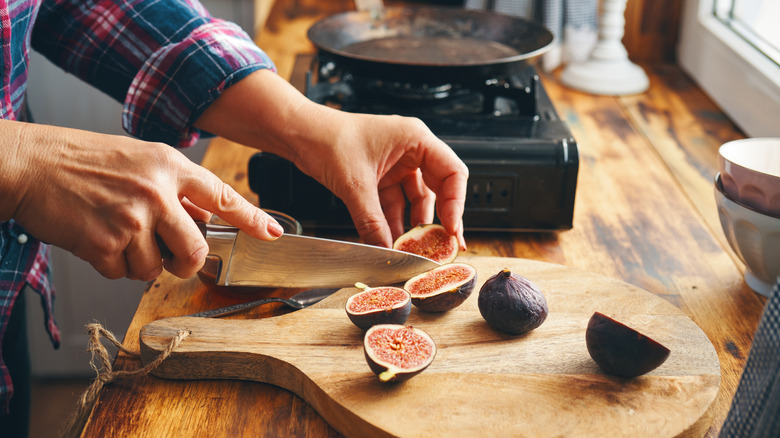 Hands slicing figs