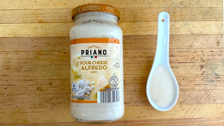 Jar and spoonful of Priano Four Cheese Alfredo Sauce