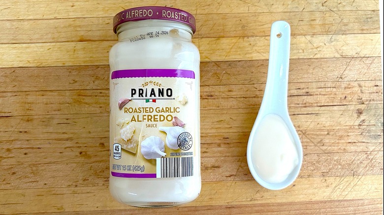 Jar and spoonful of Priano Roasted Garlic Alfredo Sauce