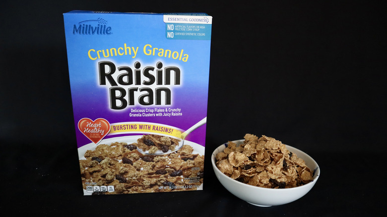 Crunchy Granola Raisin Bran box next to a bowl of cereal.