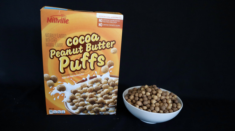 Cocoa Peanut Butter Puffs box next to a bowl of cereal.