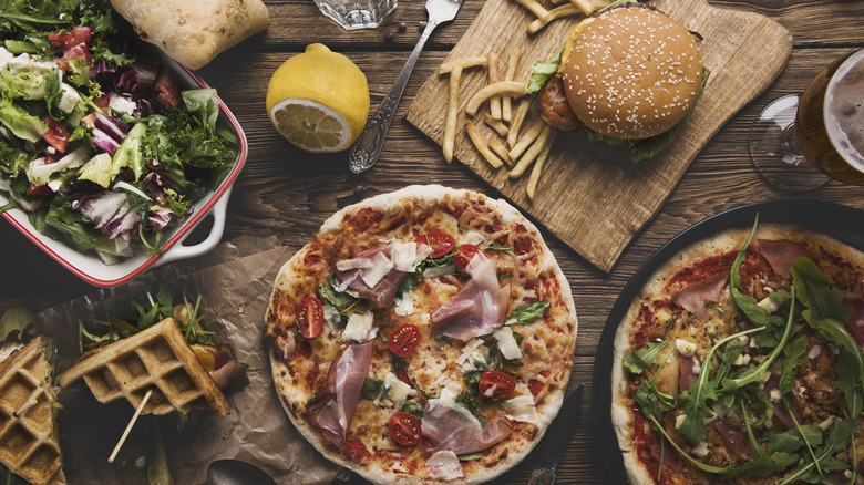Burgers, pizzas, and other food on a table