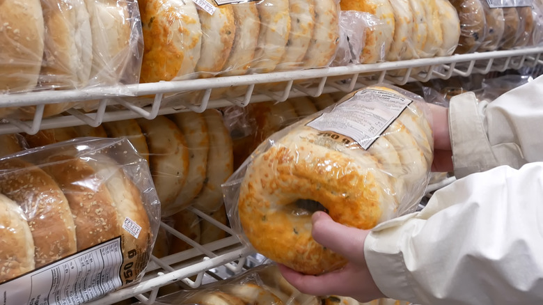 Person putting bagels on shelf