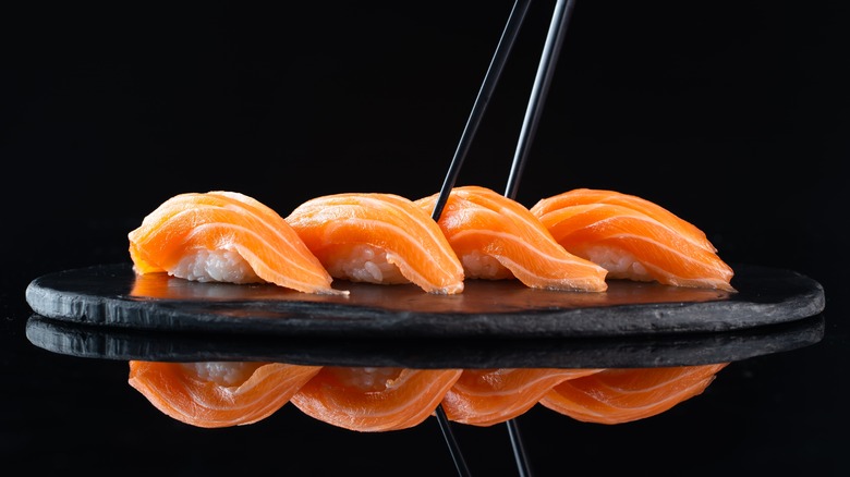 Salmon nigiri on a plate with chopsticks