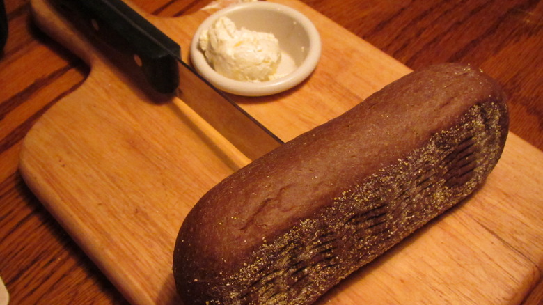 Bread with steak knife on wood board