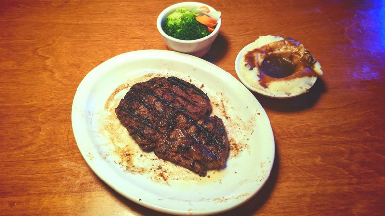 Texas Roadhouse Fort Worth ribeye on a plate with sides