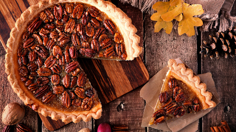 Sliced pecan pie on wood