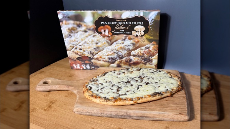 Mushroom and black truffle flatbread on a wooden board, with its box