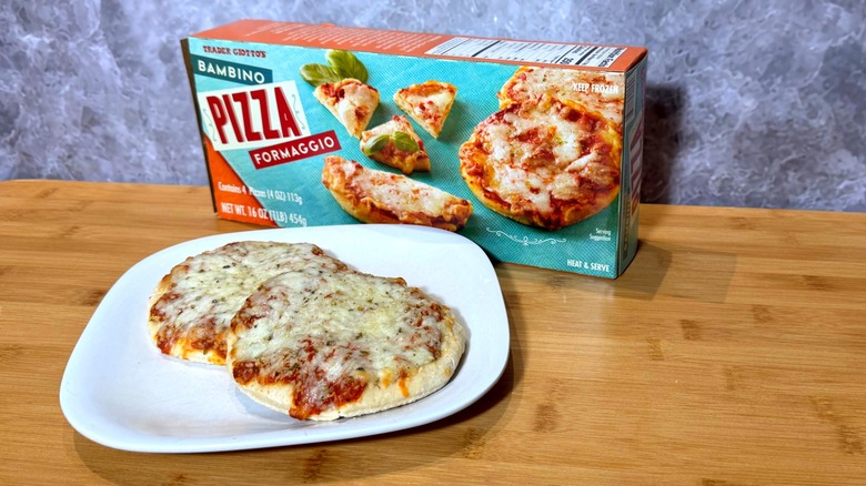 Two small cheese pizzas on a plate, next to the box