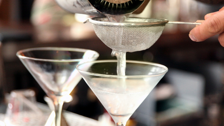 bartender straining vodka martini into glass