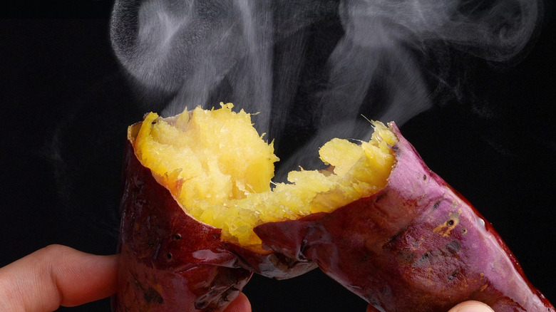 Close up of a steaming hot sweet potato broken open in two