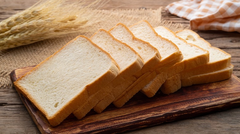 Sliced white bread on a wooden cutting board