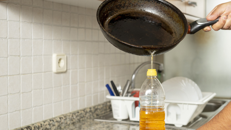 Man pouring waste oil into bottle