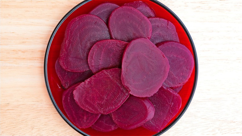 Sliced canned beets on red plate 