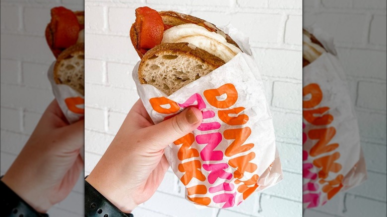 someone holding Dunkin's Sourdough Breakfast Sandwich